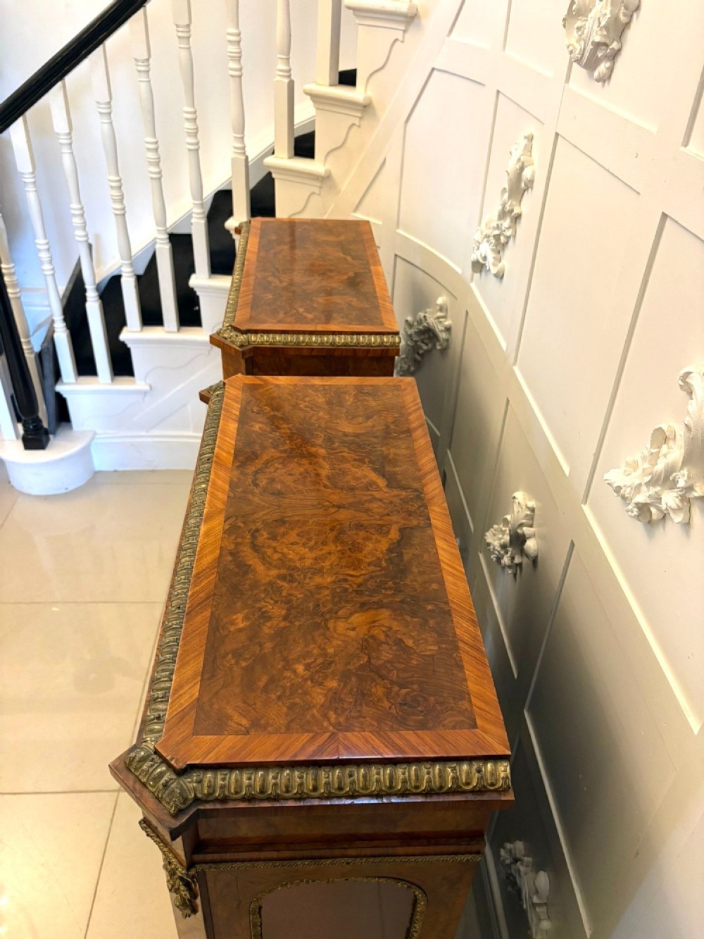 A pair of Victorian burr walnut pier cabinets featuring glazed front doors, velvet-lined interior shelves, and ornate gilt metal mounts. View IX