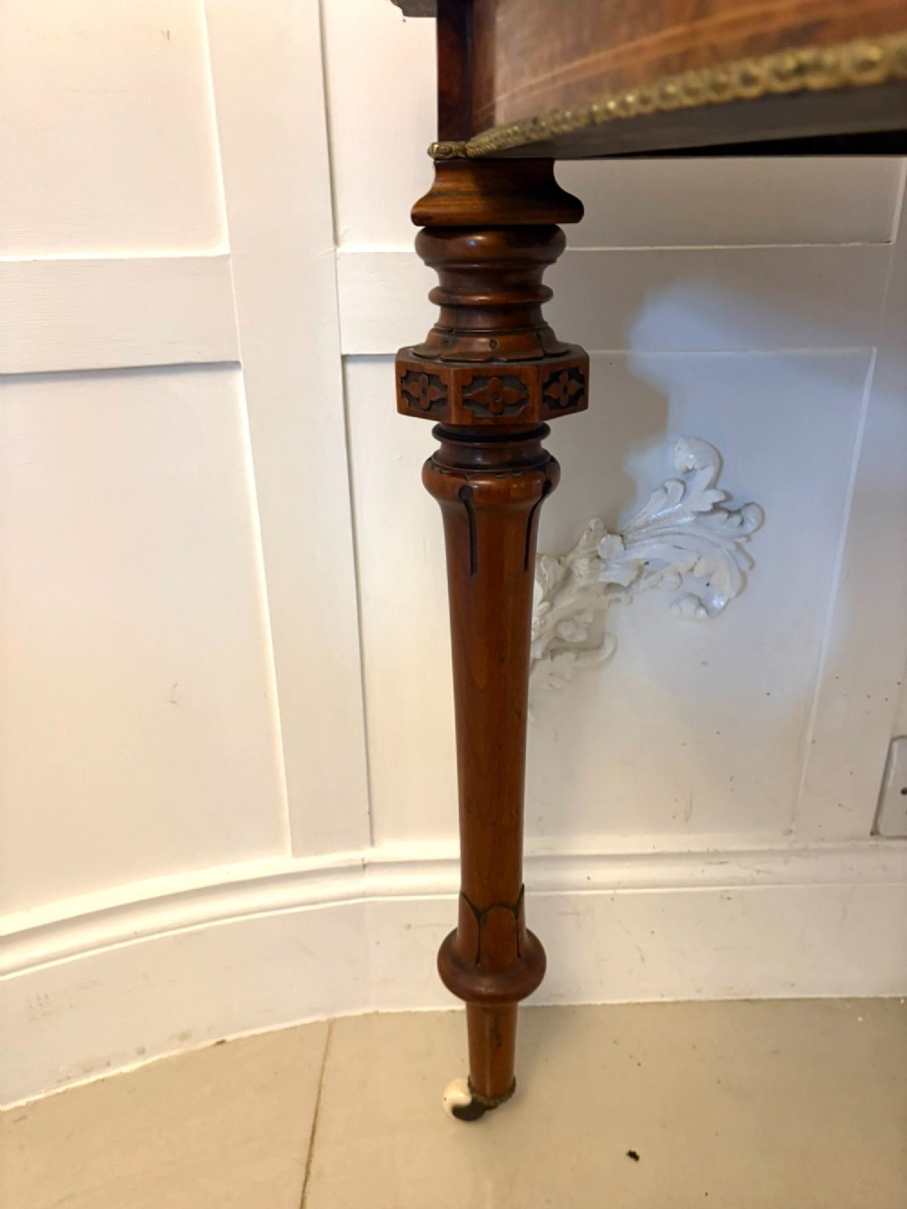 A Victorian burr walnut fold-over card table featuring geometric inlay, turned support legs on castors, and decorative brass edge moulding. View II