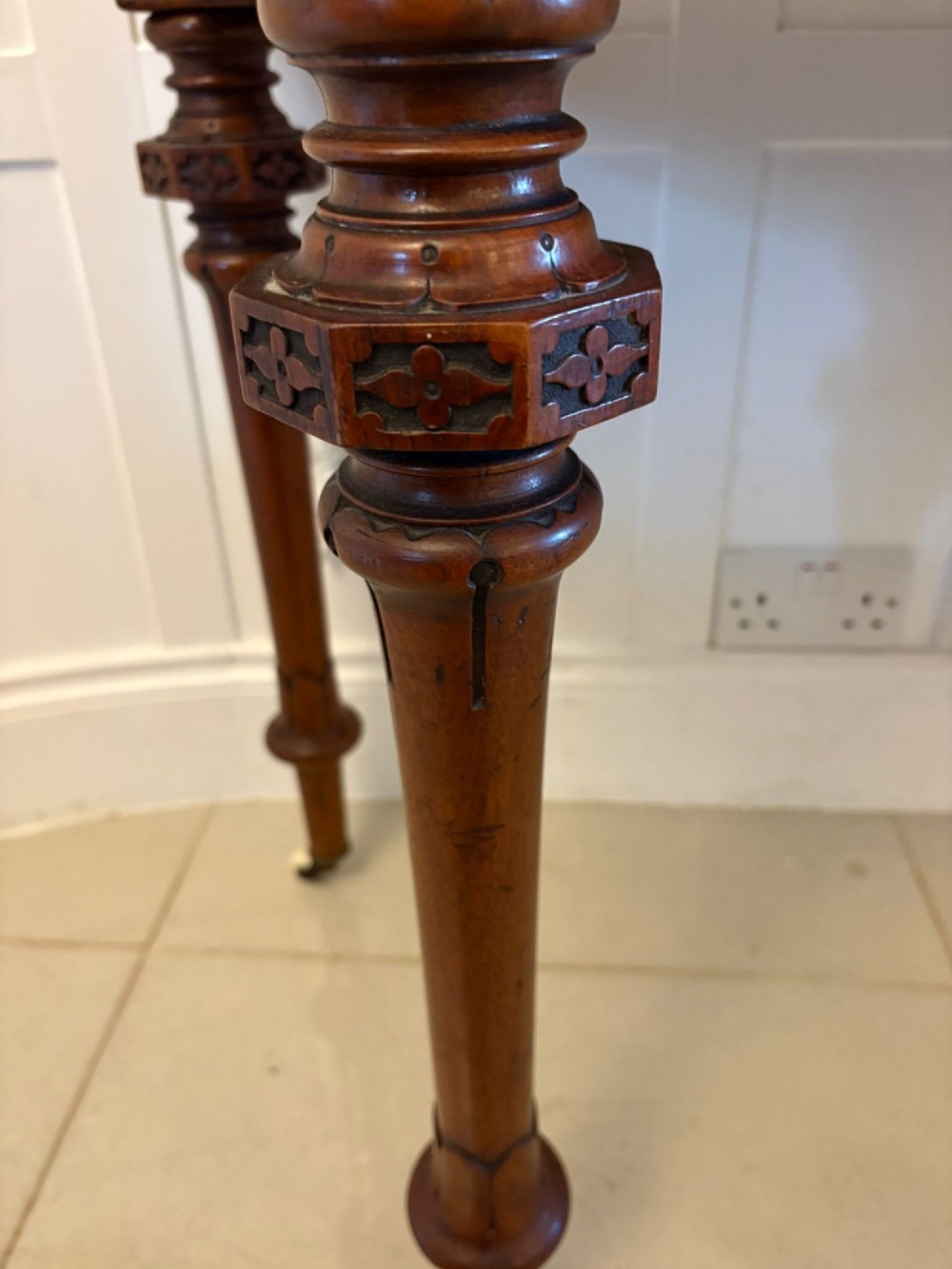A Victorian burr walnut fold-over card table featuring geometric inlay, turned support legs on castors, and decorative brass edge moulding. View III