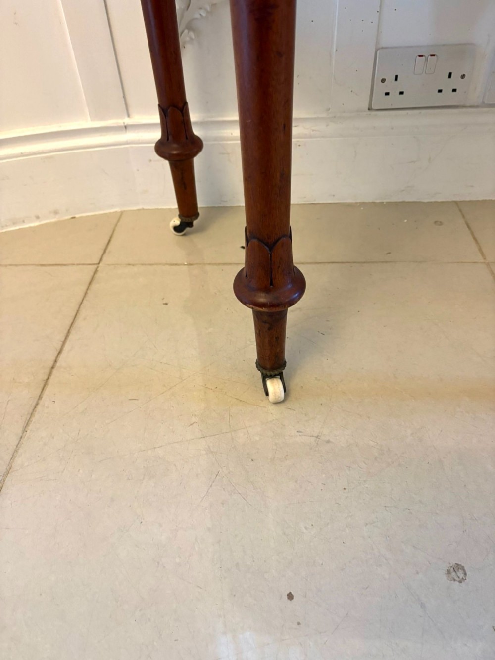 A Victorian burr walnut fold-over card table featuring geometric inlay, turned support legs on castors, and decorative brass edge moulding. View VI