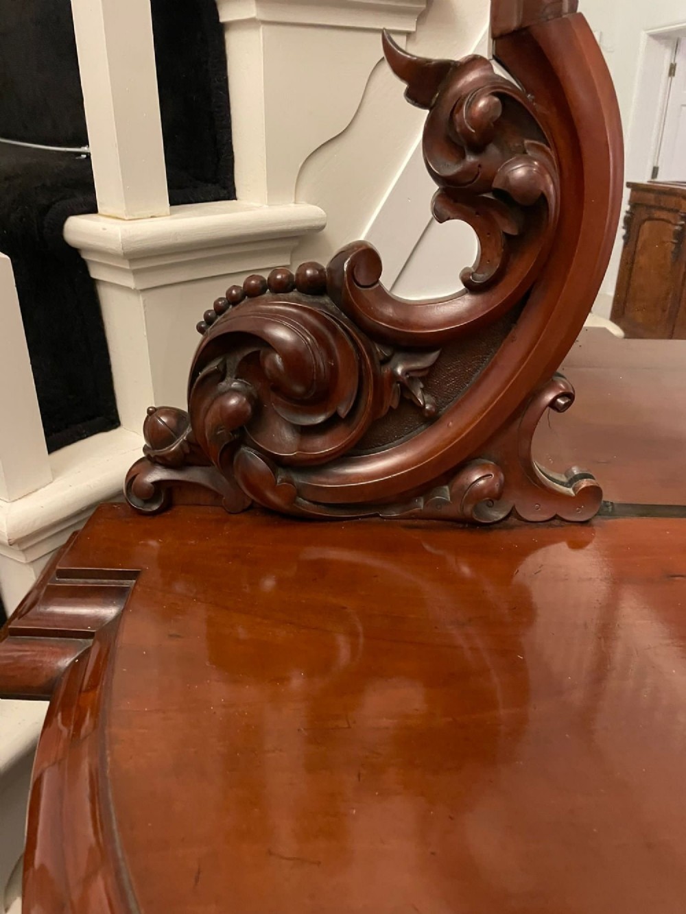 A Victorian carved mahogany sideboard featuring a curved front, open central bay, flanked cupboards, and a large arched mirror backrest adorned with scroll carving. View III