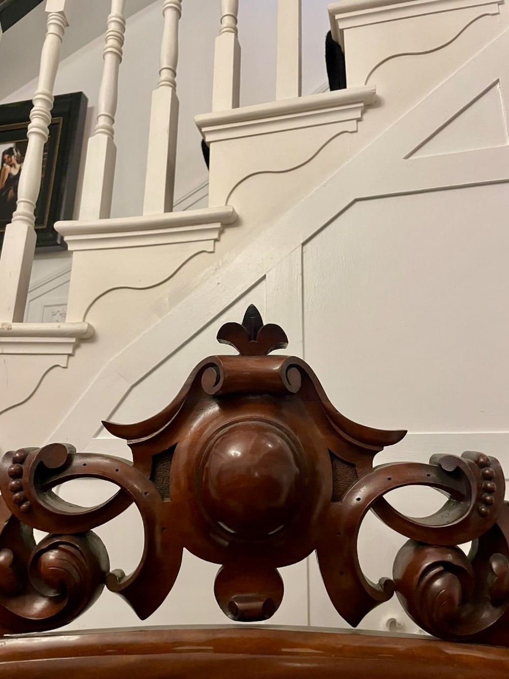 A Victorian carved mahogany sideboard featuring a curved front, open central bay, flanked cupboards, and a large arched mirror backrest adorned with scroll carving. View V