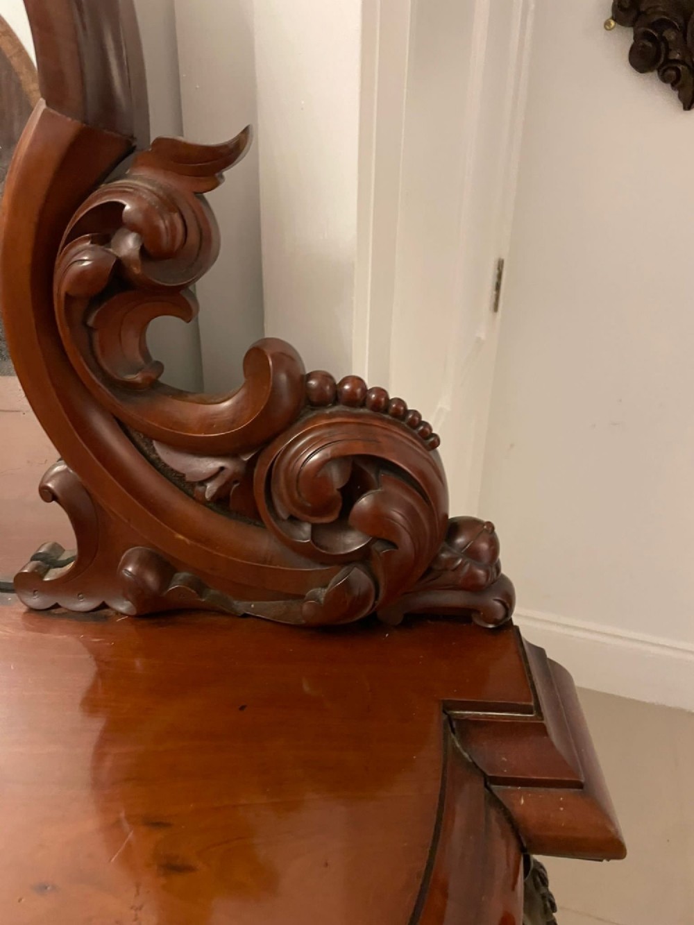 A Victorian carved mahogany sideboard featuring a curved front, open central bay, flanked cupboards, and a large arched mirror backrest adorned with scroll carving. View VI