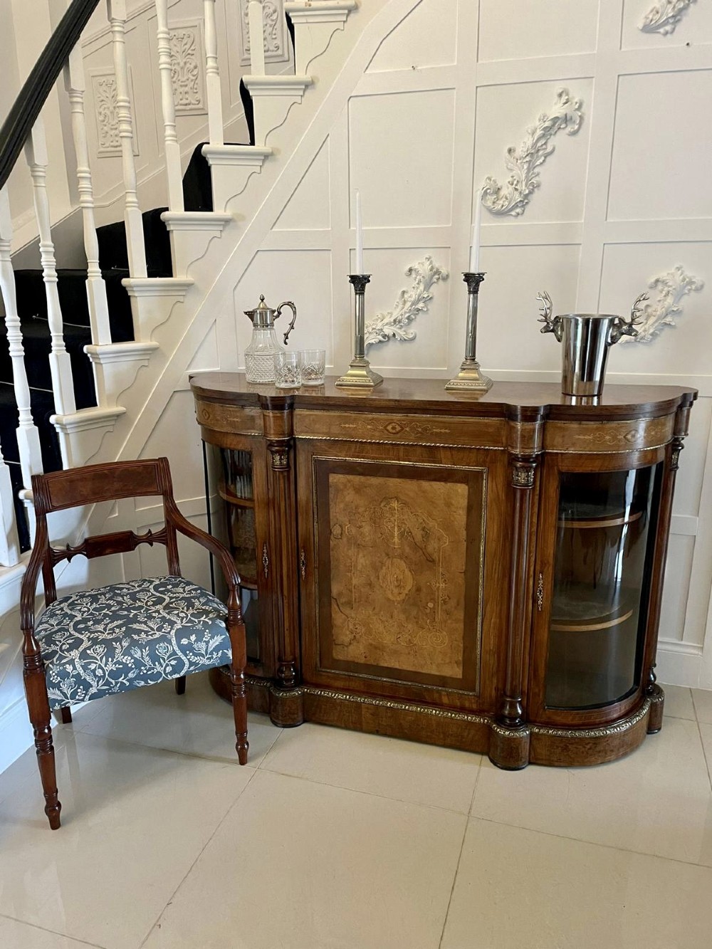 A Victorian burr walnut credenza with a central marquetry inlaid door, gilt ormolu mounts, and two curved glass side display cabinets. View VII