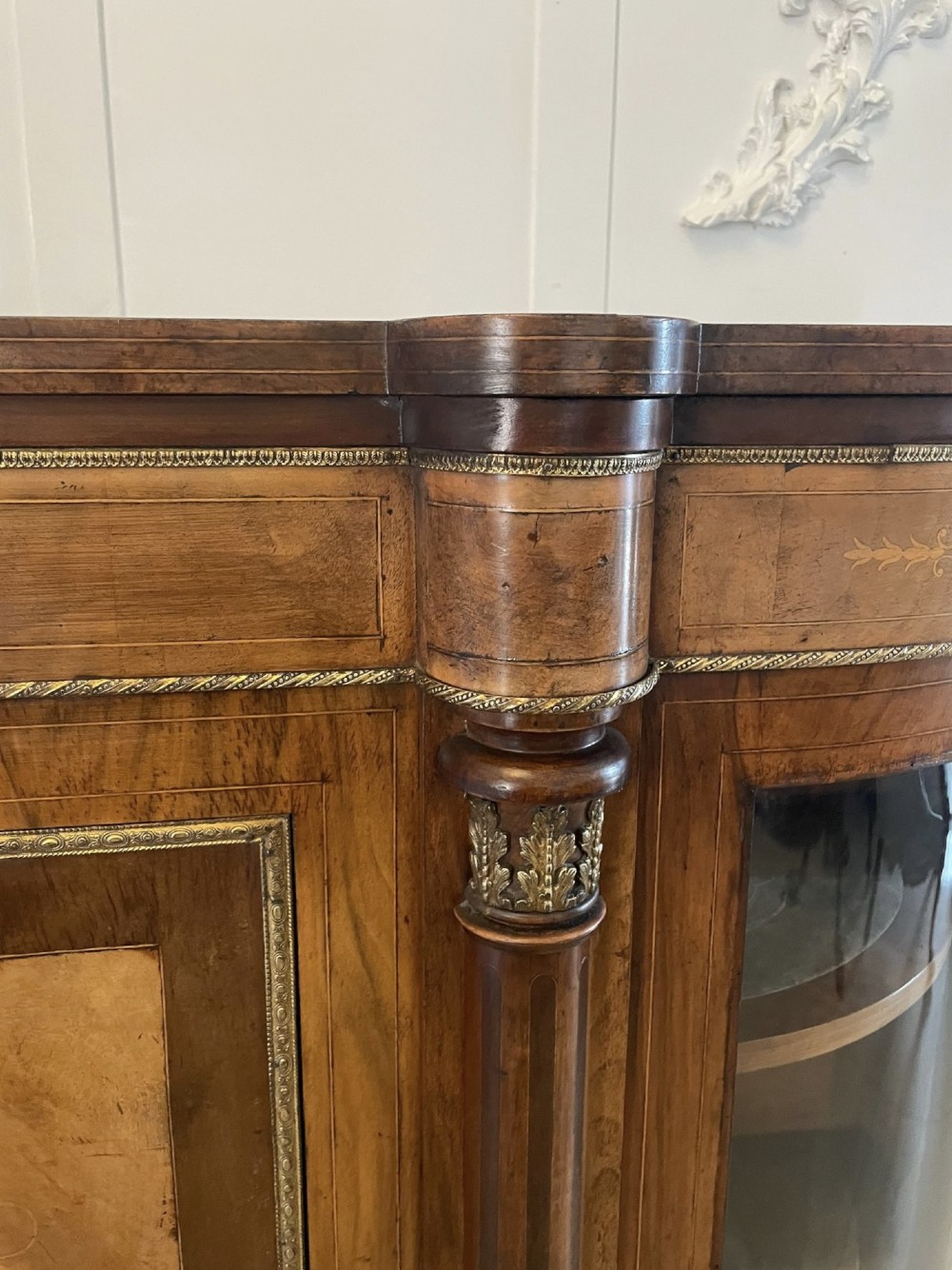A Victorian burr walnut credenza with a central marquetry inlaid door, gilt ormolu mounts, and two curved glass side display cabinets. View X