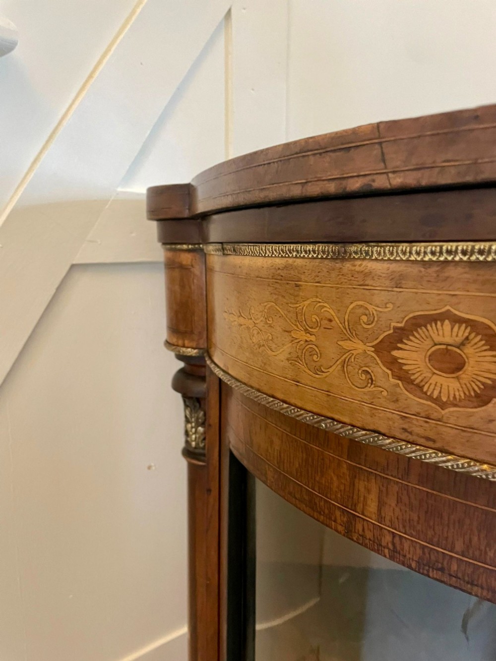 A Victorian burr walnut credenza with a central marquetry inlaid door, gilt ormolu mounts, and two curved glass side display cabinets. View XI