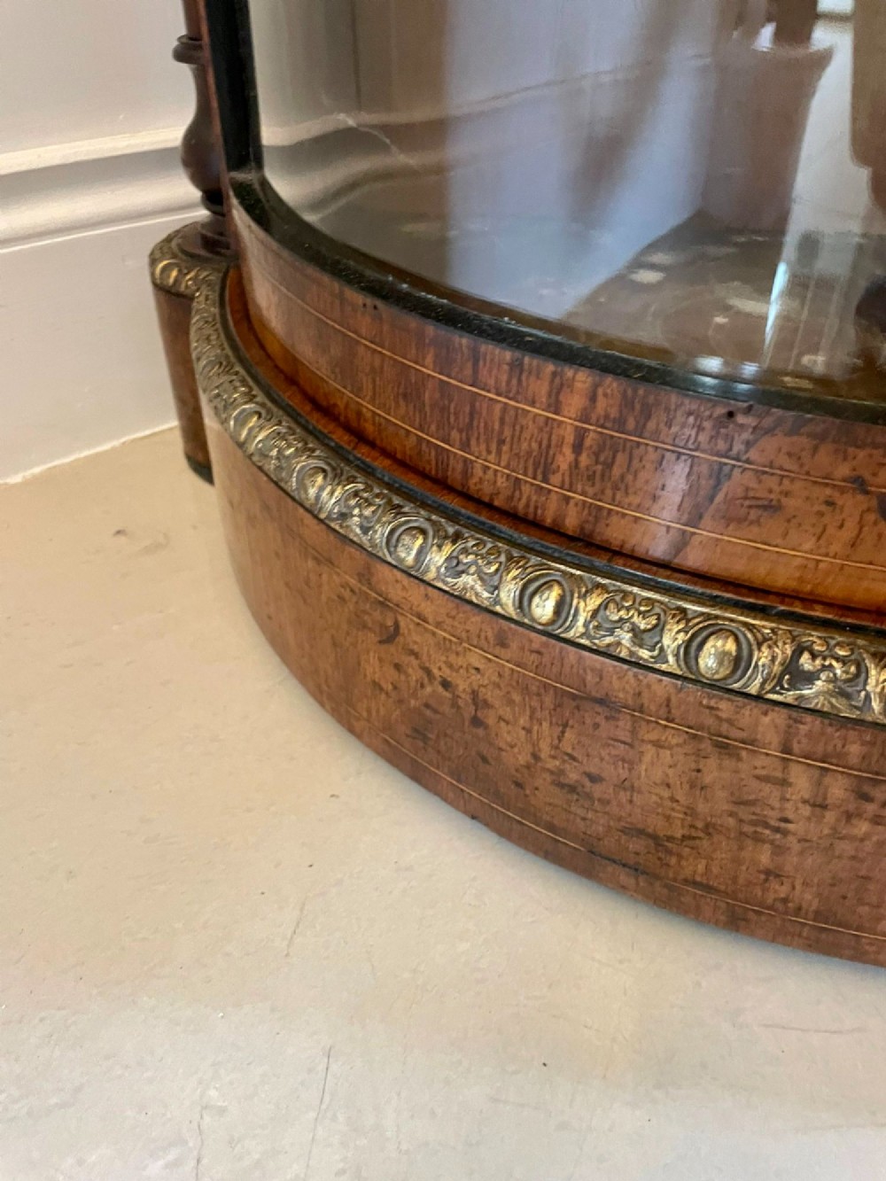 A Victorian burr walnut credenza with a central marquetry inlaid door, gilt ormolu mounts, and two curved glass side display cabinets. View XII