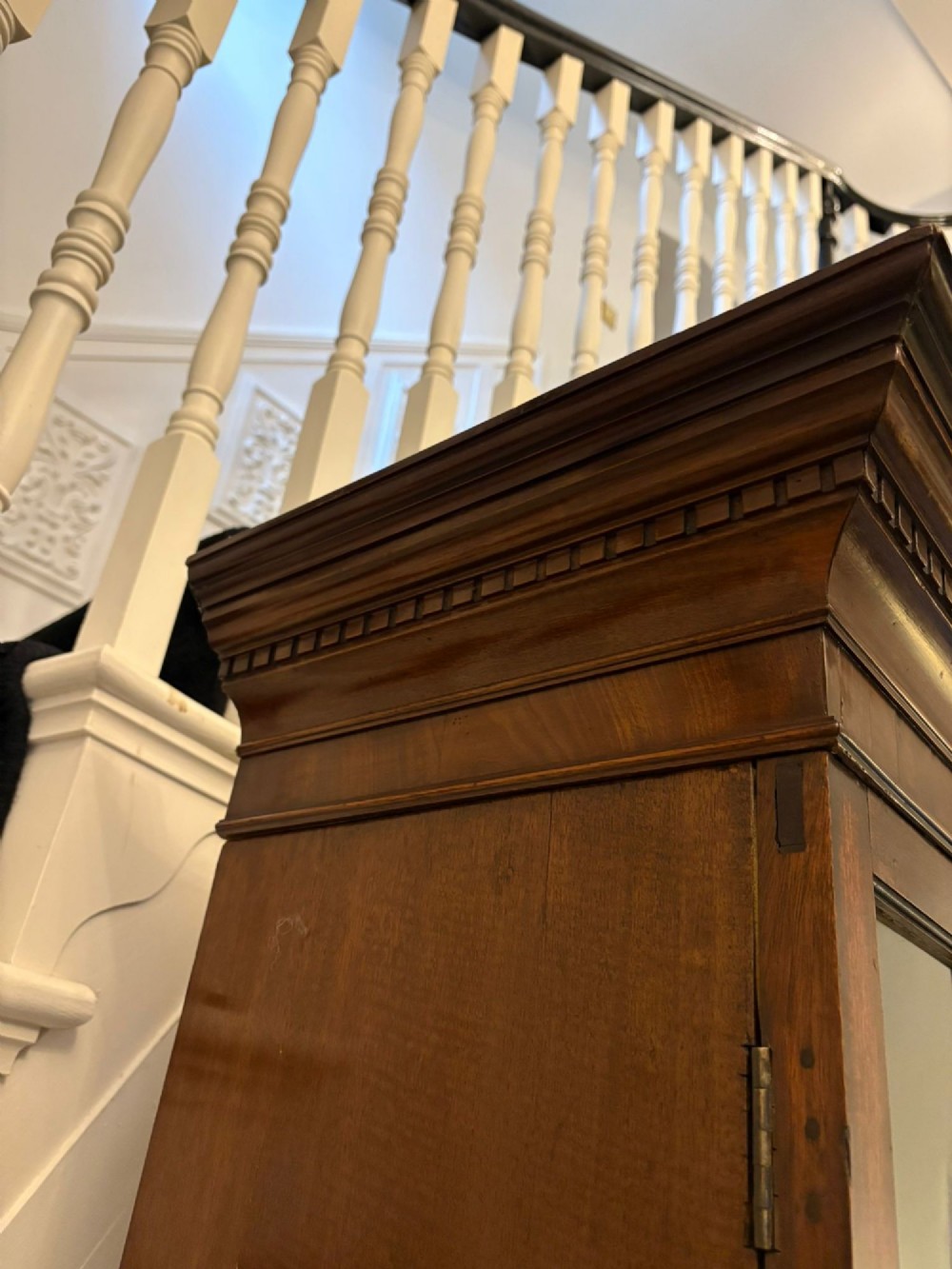 A tall antique Victorian mahogany bookcase featuring a pierced swan-neck pediment, astragal glazed double doors, and carved legs. View X