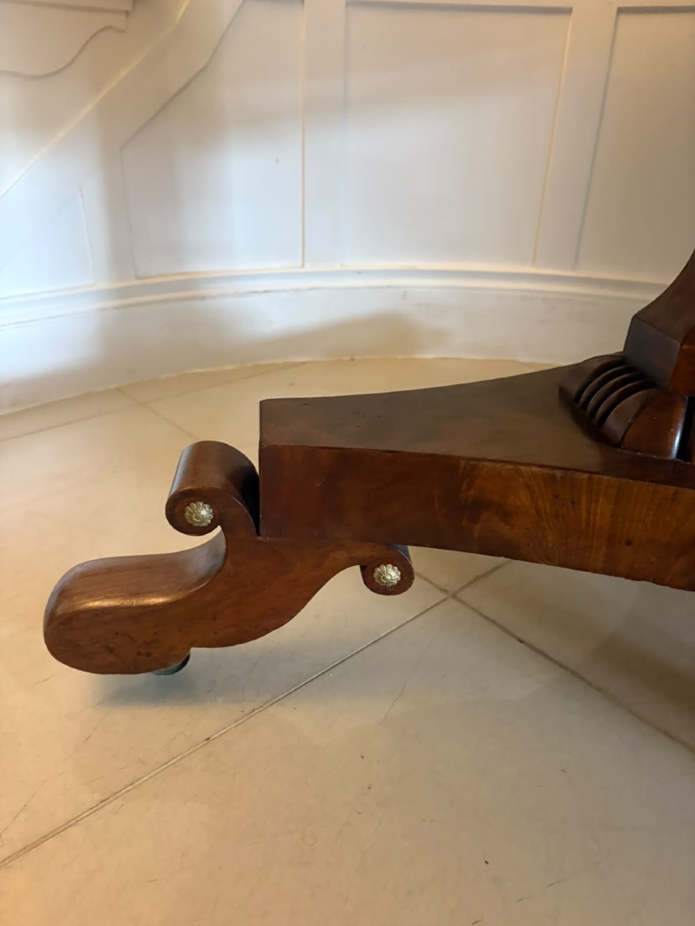 A circular Regency tilt-top centre table featuring highly figured flame mahogany veneers, shown in the upright position on a scrolled pedestal base with brass castors. View VIII