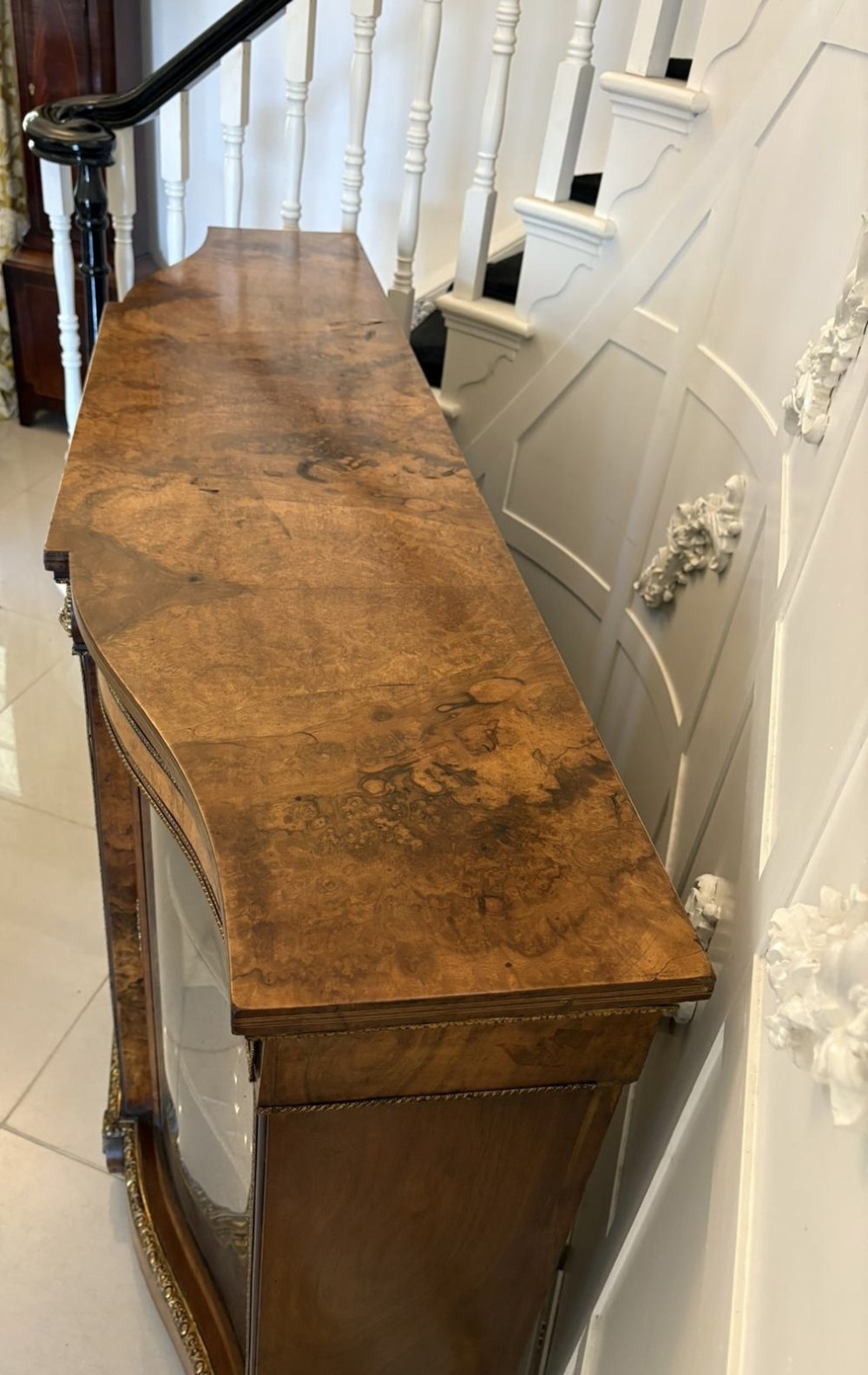 A Victorian burr walnut credenza featuring a central oval mirrored door flanked by curved bow-front glass doors and gilt ormolu mounts. View VI