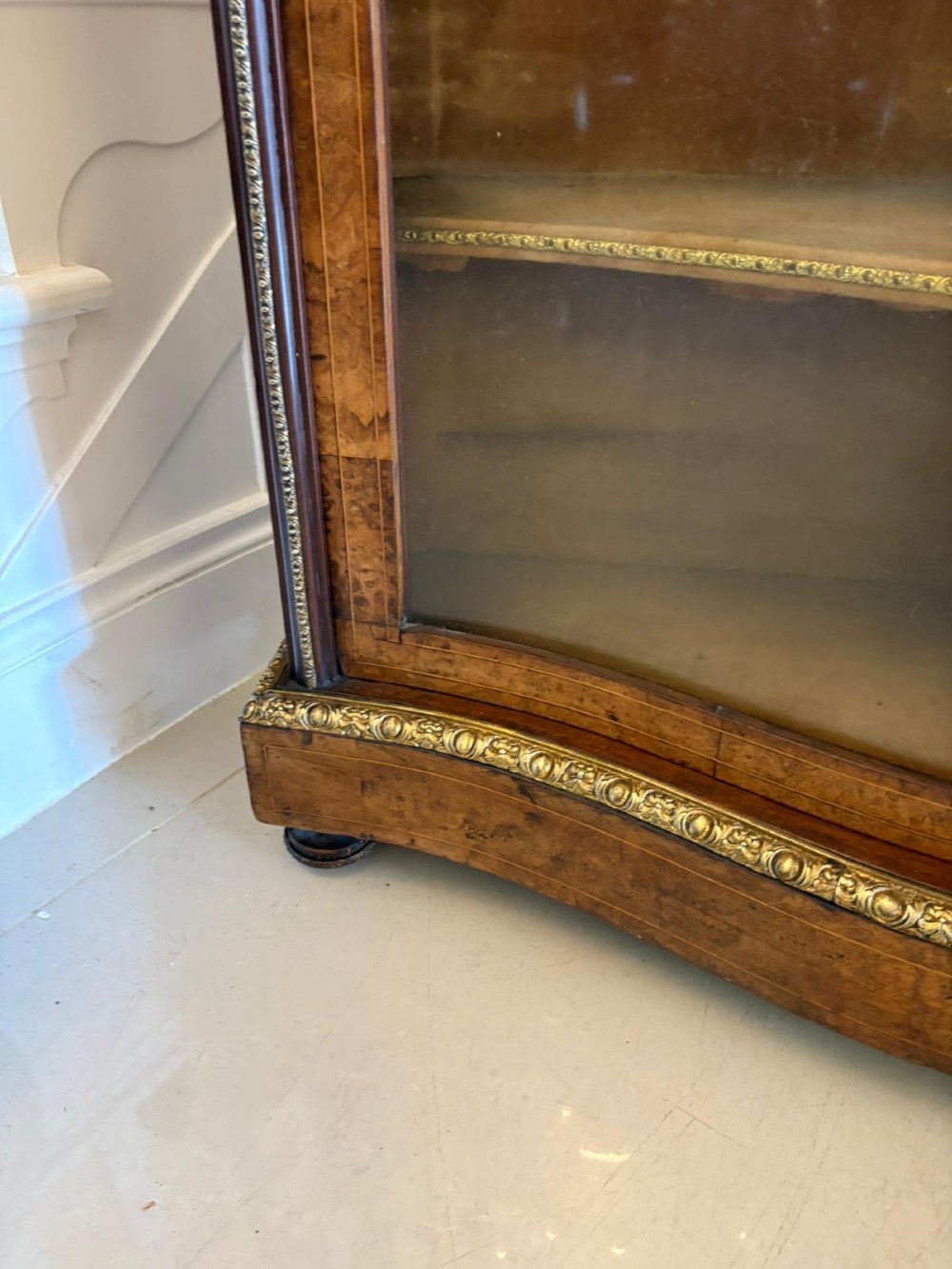 A Victorian burr walnut credenza featuring a central oval mirrored door flanked by curved bow-front glass doors and gilt ormolu mounts. View VII