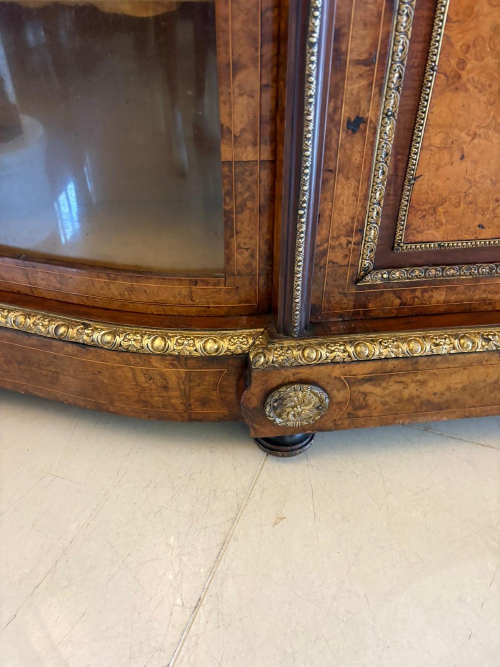 A Victorian burr walnut credenza featuring a central oval mirrored door flanked by curved bow-front glass doors and gilt ormolu mounts. View VIII