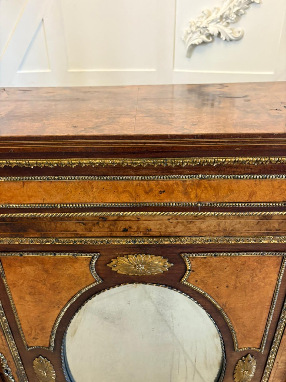 A Victorian burr walnut credenza featuring a central oval mirrored door flanked by curved bow-front glass doors and gilt ormolu mounts. View X