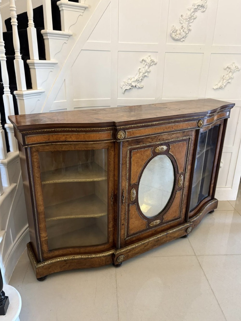 A Victorian burr walnut credenza featuring a central oval mirrored door flanked by curved bow-front glass doors and gilt ormolu mounts. View XIV