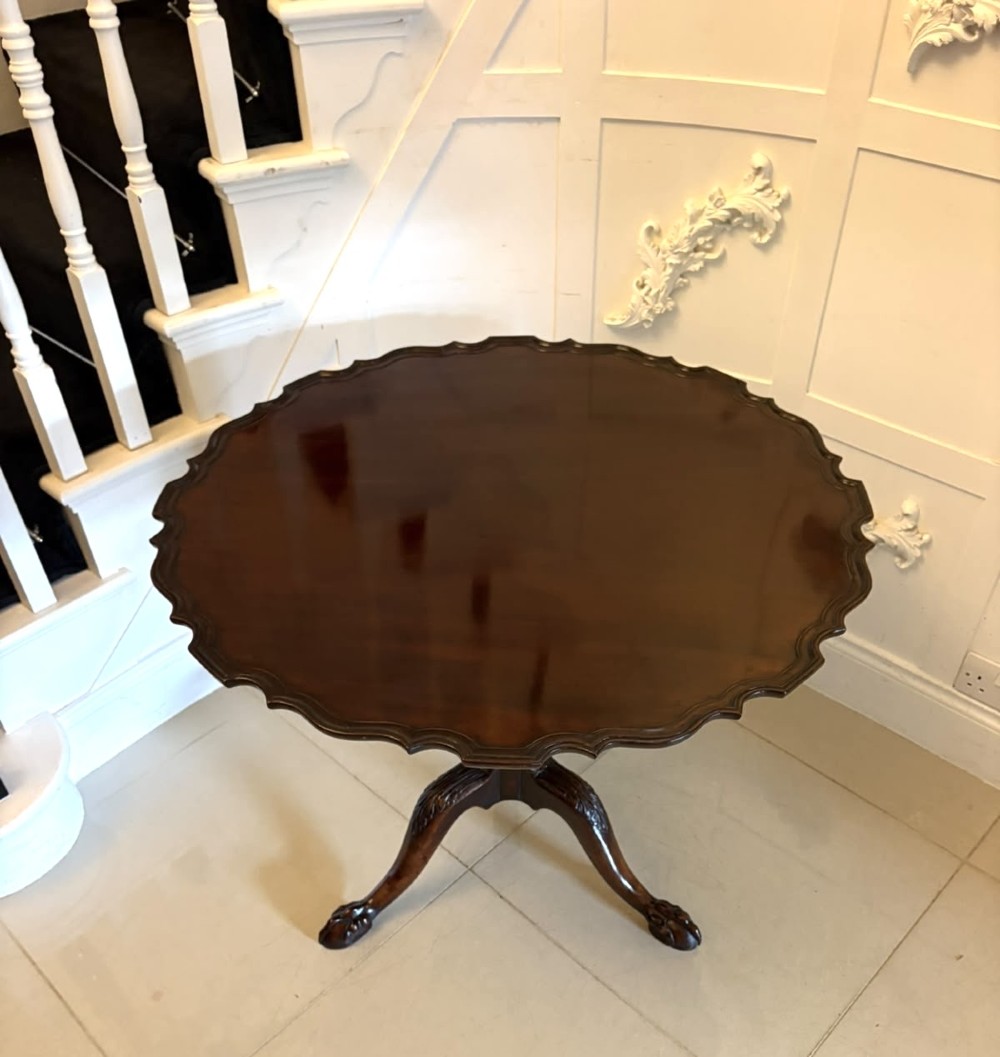 A mahogany George III style tilt-top centre table featuring a scalloped piecrust edge, central pedestal, and tripod cabriole legs with claw and ball feet. View VIII