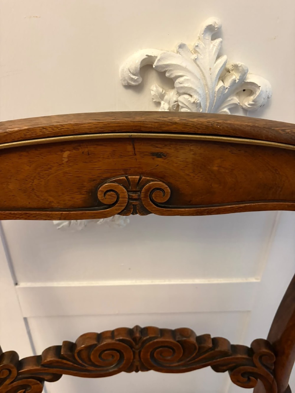 A set of four antique Regency rosewood dining chairs featuring carved scroll top rails and pattern-upholstered seats on turned front legs. View X