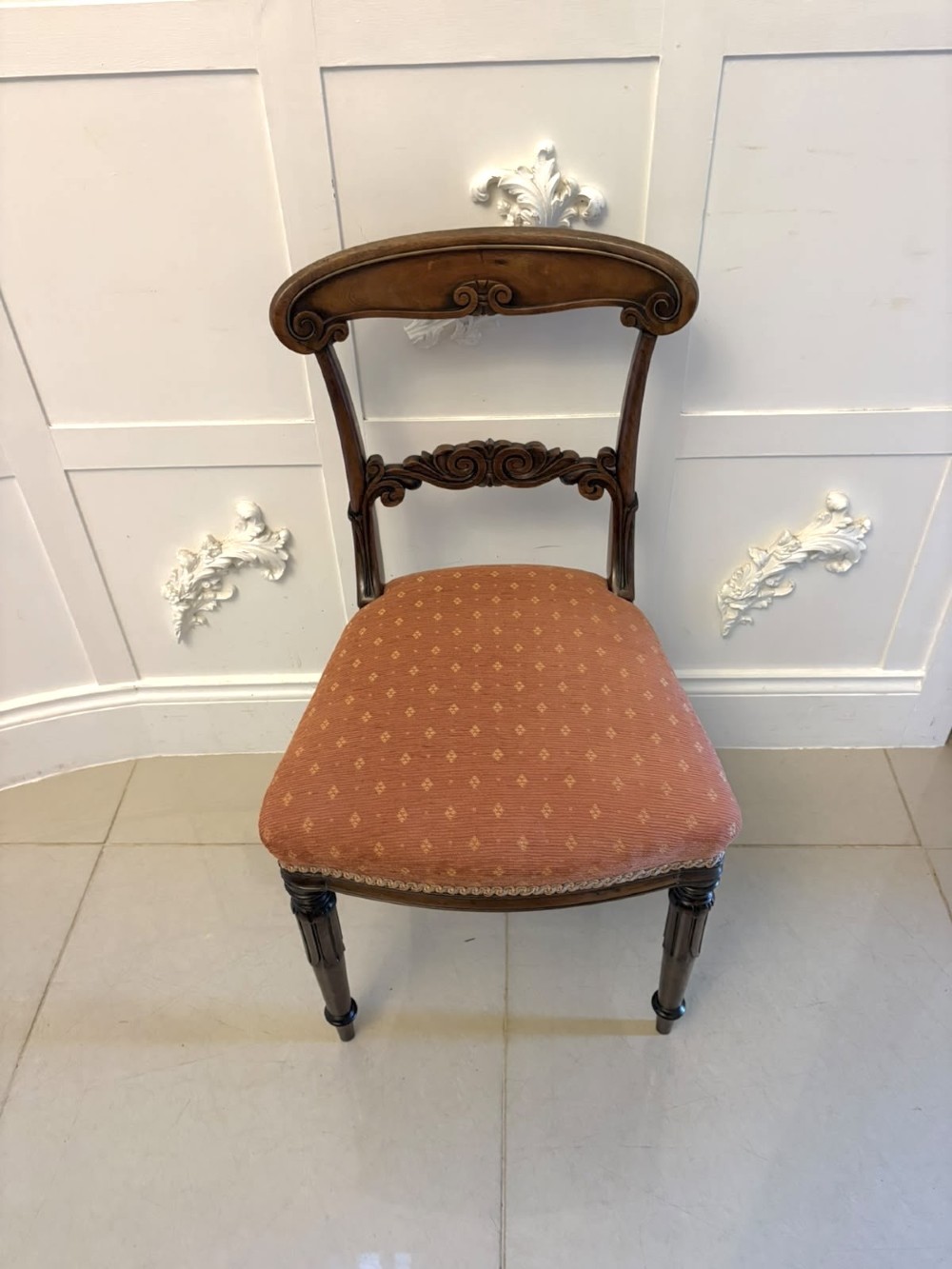 A set of four antique Regency rosewood dining chairs featuring carved scroll top rails and pattern-upholstered seats on turned front legs. View XIV