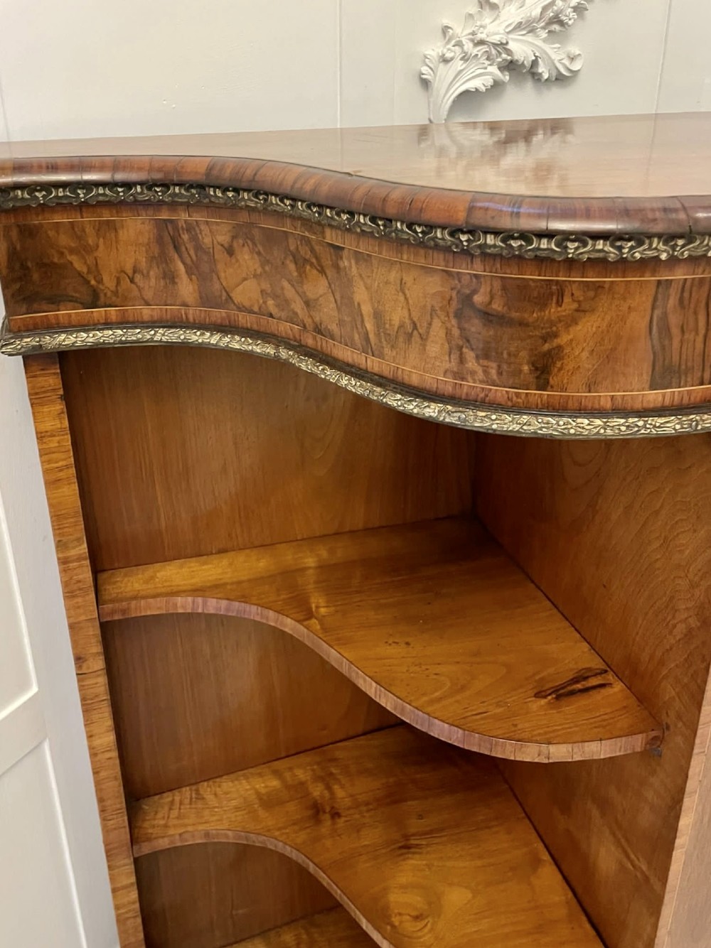 A Victorian burr walnut credenza featuring a central glass door, open serpentine display shelves, and detailed brass ormolu mounts. View XI