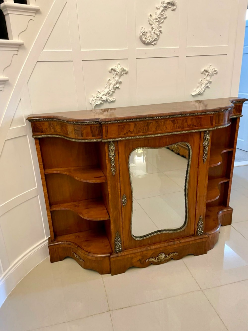 A Victorian burr walnut credenza featuring a central glass door, open serpentine display shelves, and detailed brass ormolu mounts. View XIII