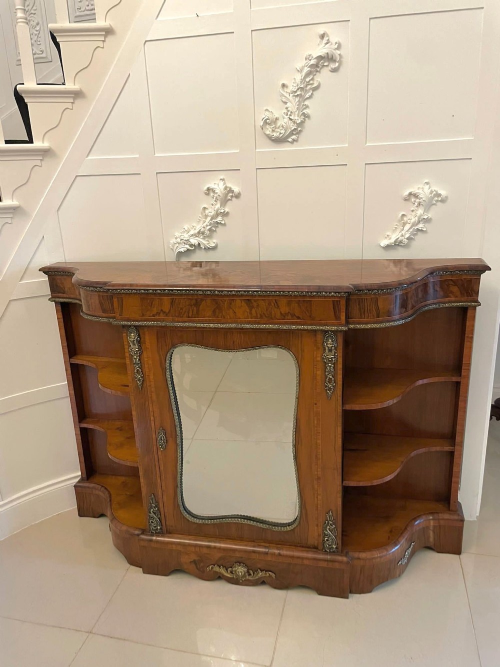 A Victorian burr walnut credenza featuring a central glass door, open serpentine display shelves, and detailed brass ormolu mounts. View XIV