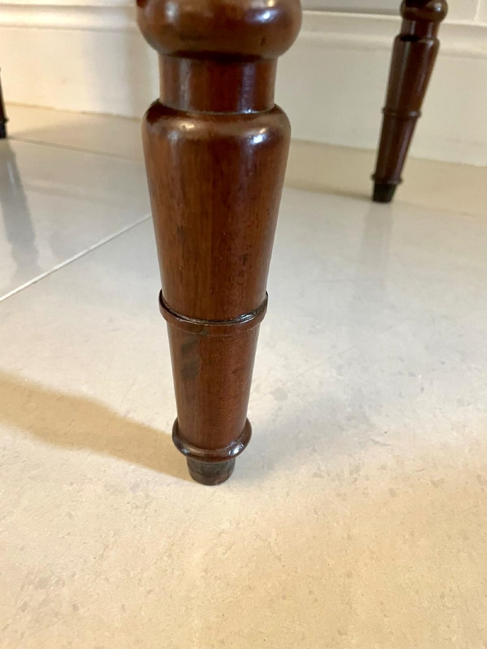 A Georgian mahogany cellarette featuring a tapered rectangular body on turned legs with brass lion-mask side handles and a keyhole lid. View V