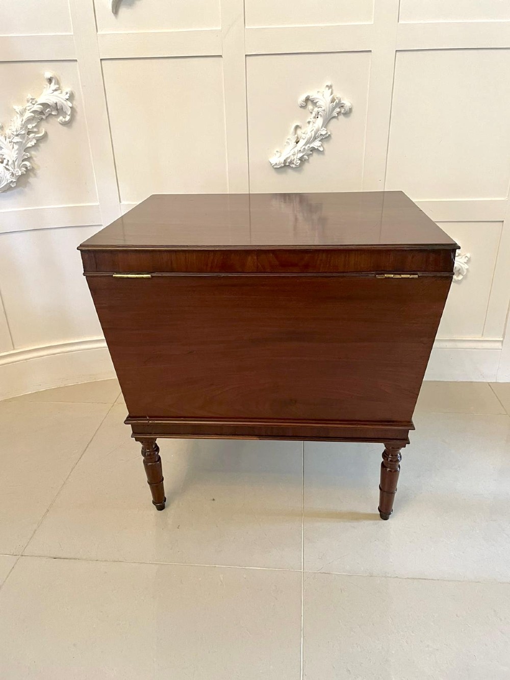 A Georgian mahogany cellarette featuring a tapered rectangular body on turned legs with brass lion-mask side handles and a keyhole lid. View VI