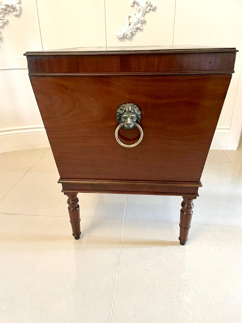 A Georgian mahogany cellarette featuring a tapered rectangular body on turned legs with brass lion-mask side handles and a keyhole lid. View VII