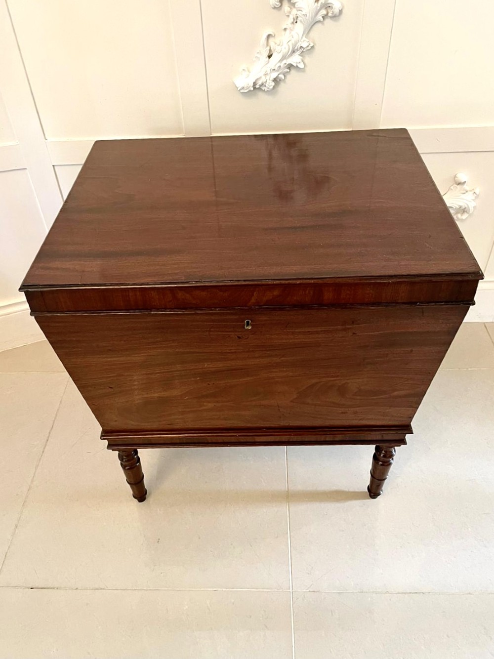 A Georgian mahogany cellarette featuring a tapered rectangular body on turned legs with brass lion-mask side handles and a keyhole lid. View VIII