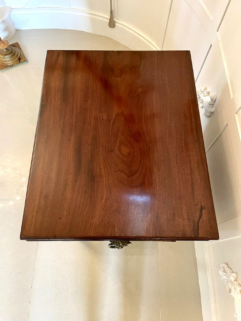 A Georgian mahogany cellarette featuring a tapered rectangular body on turned legs with brass lion-mask side handles and a keyhole lid. View X