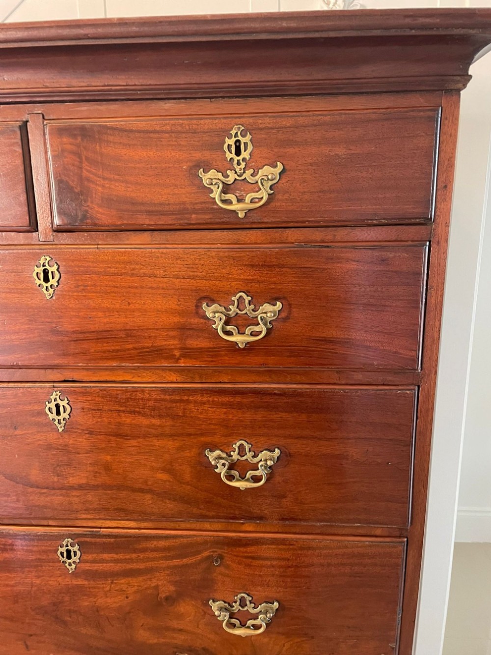 An antique Georgian mahogany chest on chest featuring eight drawers with brass swan-neck handles, keyhole escutcheons, and bracket feet. View X