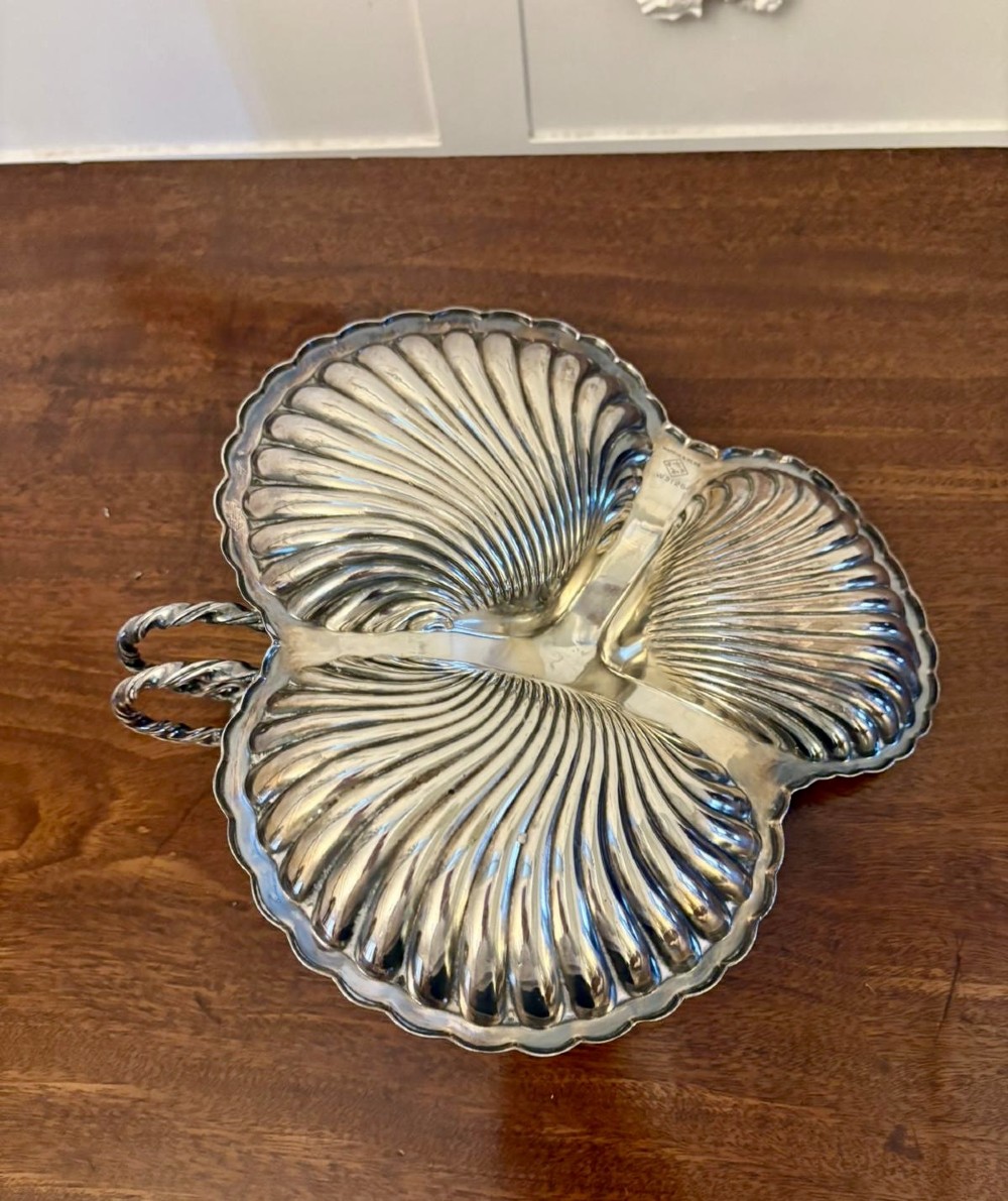 An Edwardian silver-plated tripartite serving dish featuring three fluted shell-shaped compartments joined by a central twisted handle. View II