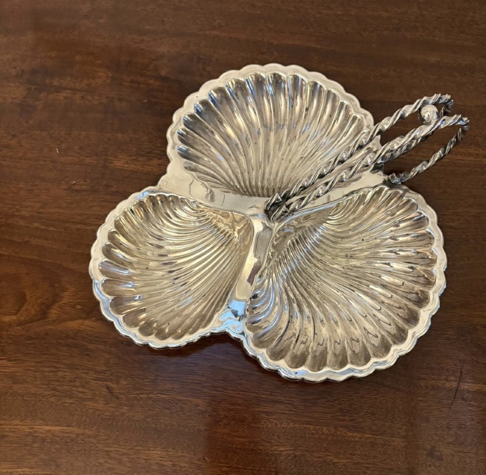An Edwardian silver-plated tripartite serving dish featuring three fluted shell-shaped compartments joined by a central twisted handle. View VI