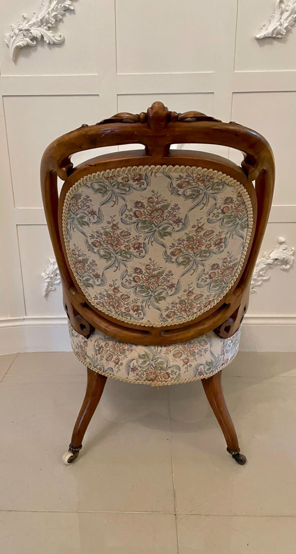 A pair of Victorian carved walnut side chairs featuring button-tufted floral upholstery and cabriole legs with ceramic castors. View III