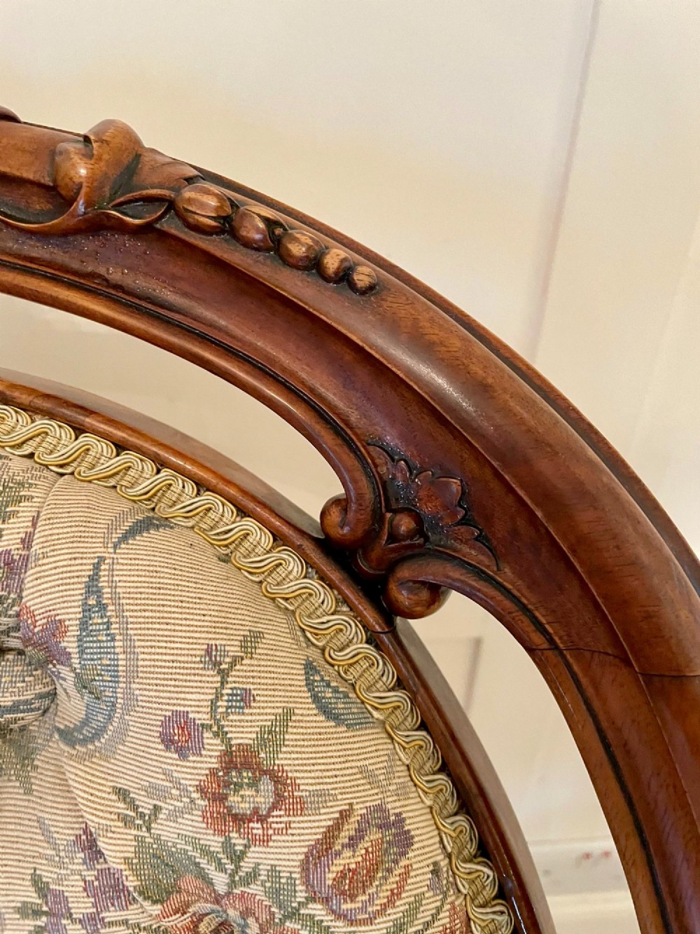 A pair of Victorian carved walnut side chairs featuring button-tufted floral upholstery and cabriole legs with ceramic castors. View IV