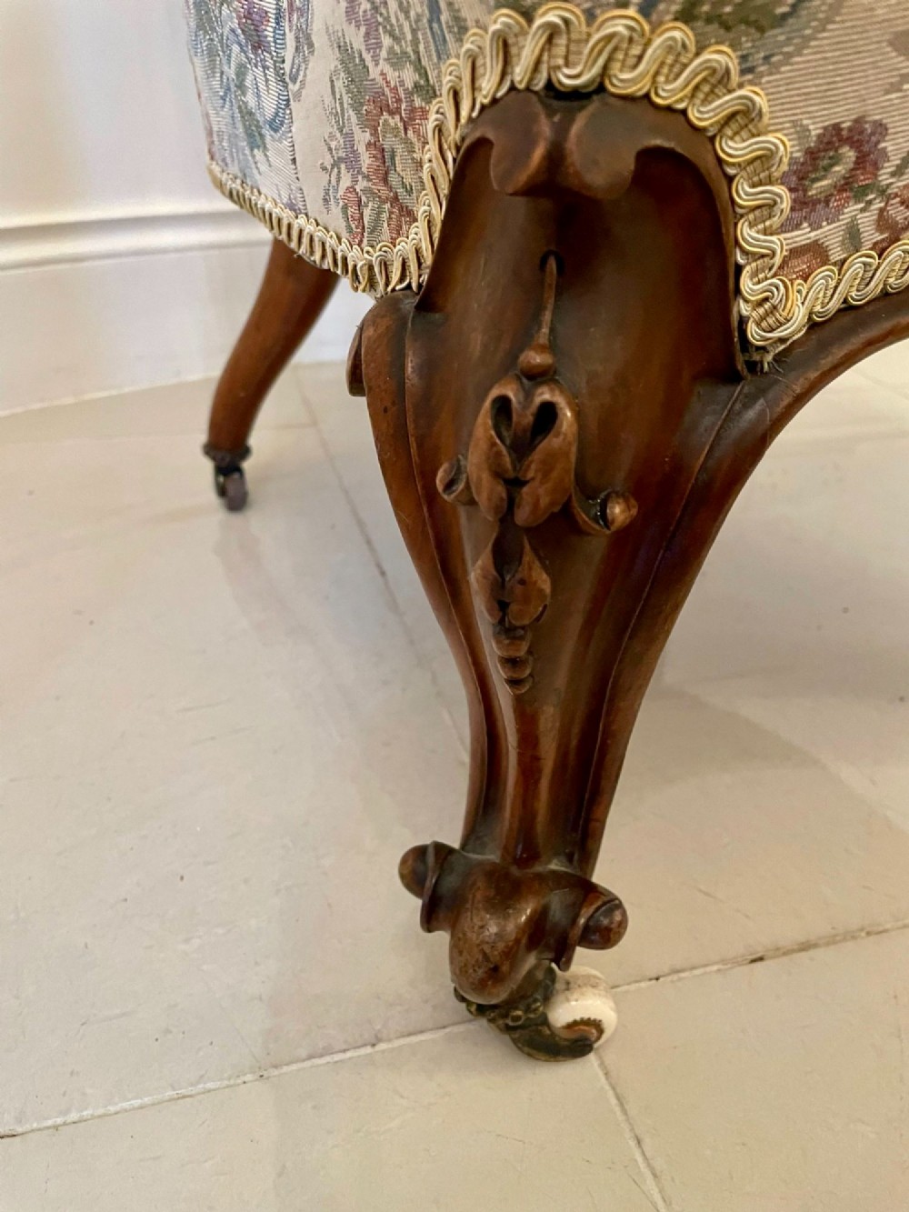A pair of Victorian carved walnut side chairs featuring button-tufted floral upholstery and cabriole legs with ceramic castors. View IX