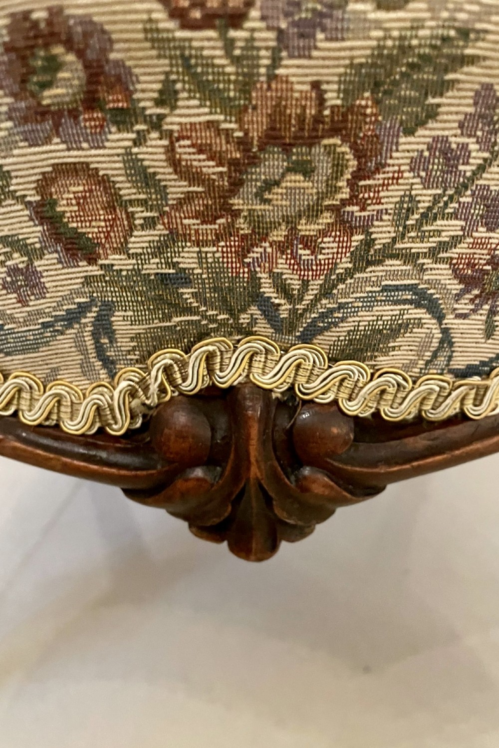 A pair of Victorian carved walnut side chairs featuring button-tufted floral upholstery and cabriole legs with ceramic castors. View X