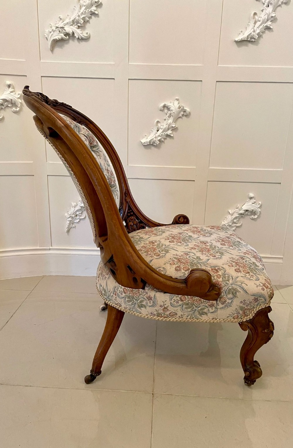 A pair of Victorian carved walnut side chairs featuring button-tufted floral upholstery and cabriole legs with ceramic castors. View XIV