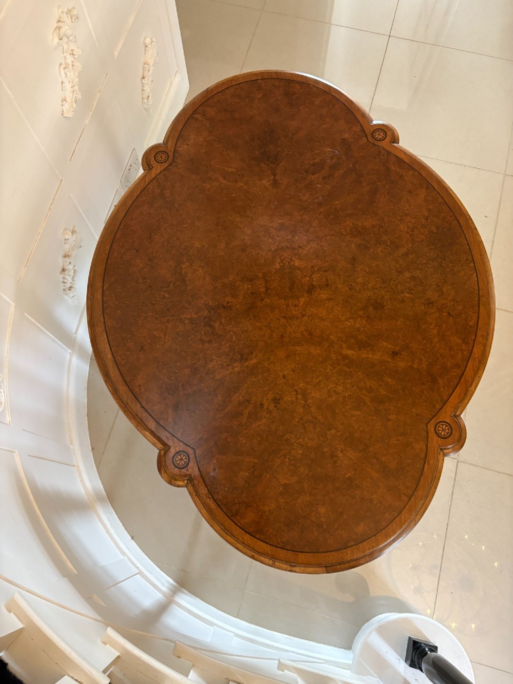 An antique Victorian burr walnut centre table featuring a shaped top with marquetry inlay, turned fluted legs, an X-frame stretcher, and ceramic castors. View III