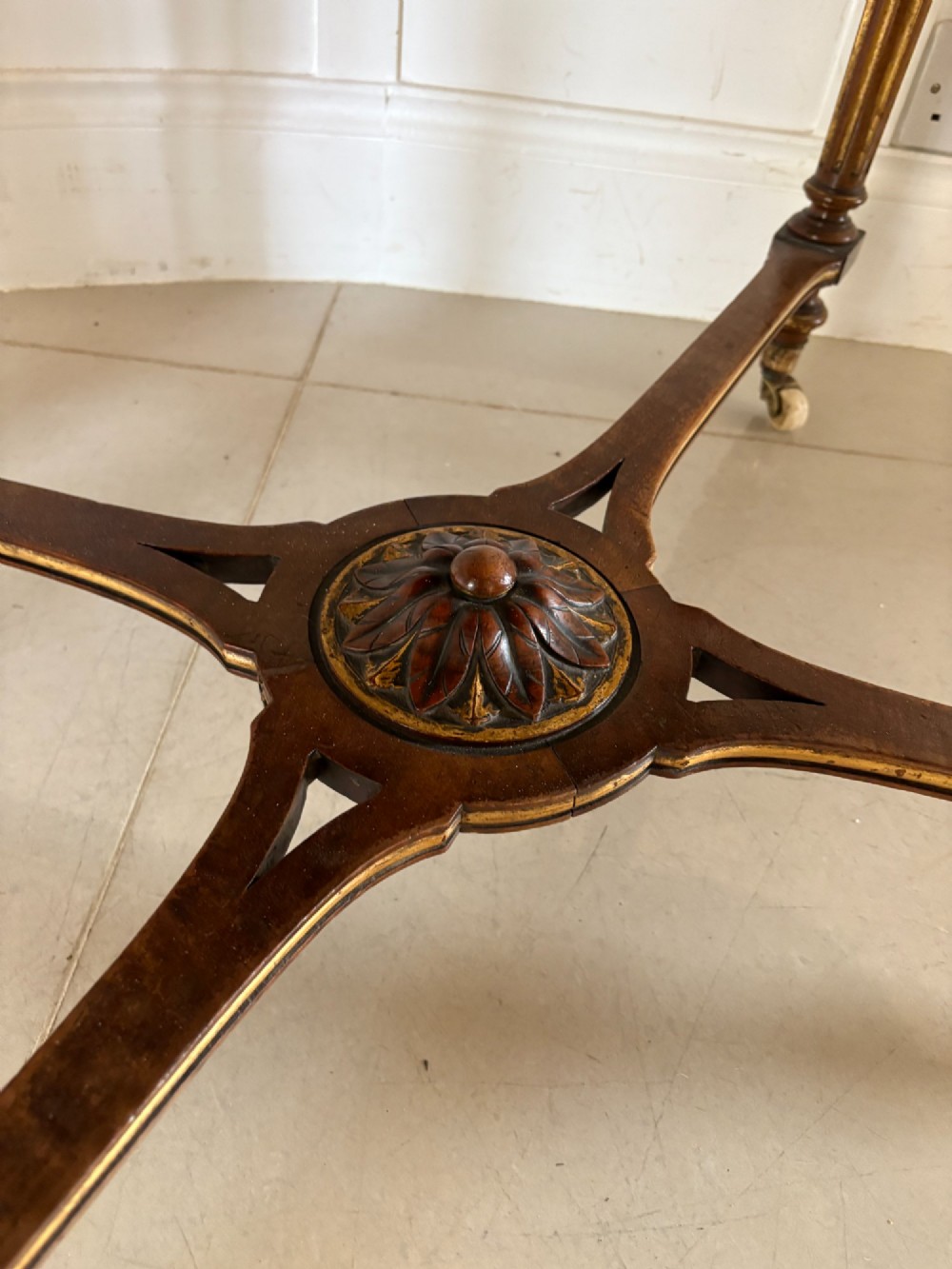 An antique Victorian burr walnut centre table featuring a shaped top with marquetry inlay, turned fluted legs, an X-frame stretcher, and ceramic castors. View VII