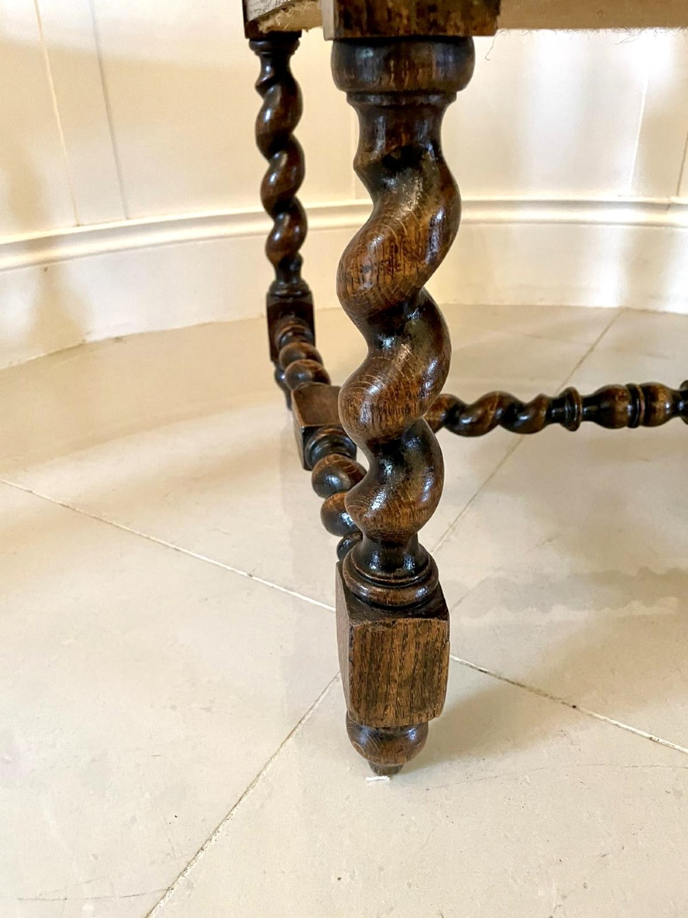 A high-backed Victorian carved oak armchair featuring barley twist supports, acanthus leaf carvings, and a burgundy leather seat with brass stud detail. View XV