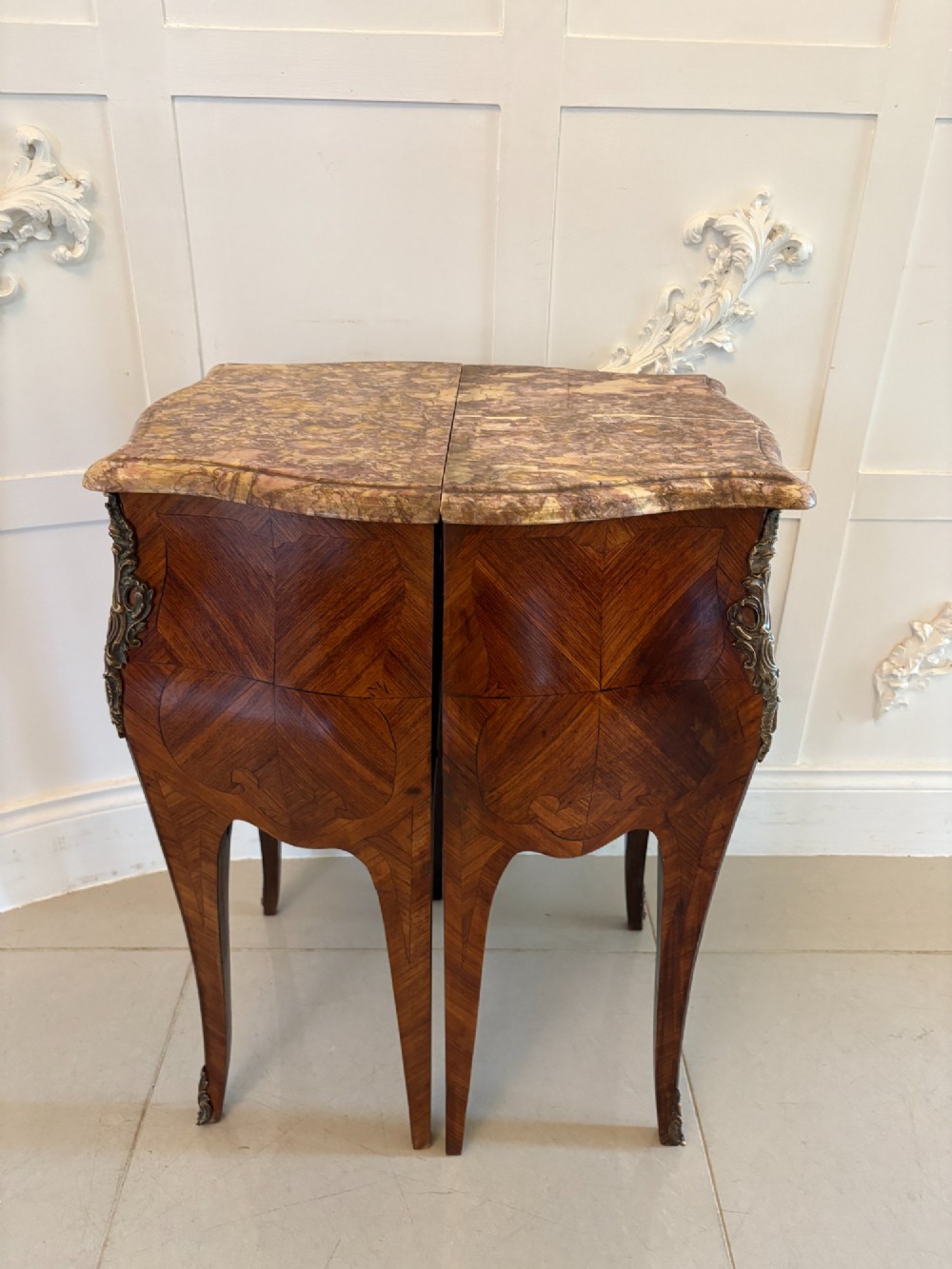 A pair of French Louis XV style kingwood bedside cabinets featuring two drawers, marquetry inlay, gilt bronze mounts, and serpentine marble tops. View VII