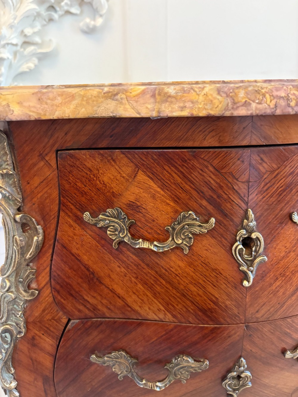 A pair of French Louis XV style kingwood bedside cabinets featuring two drawers, marquetry inlay, gilt bronze mounts, and serpentine marble tops. View X
