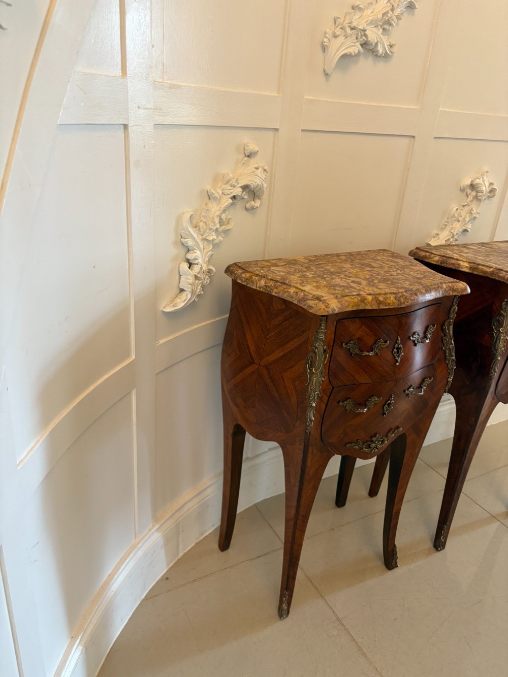 A pair of French Louis XV style kingwood bedside cabinets featuring two drawers, marquetry inlay, gilt bronze mounts, and serpentine marble tops. View XII