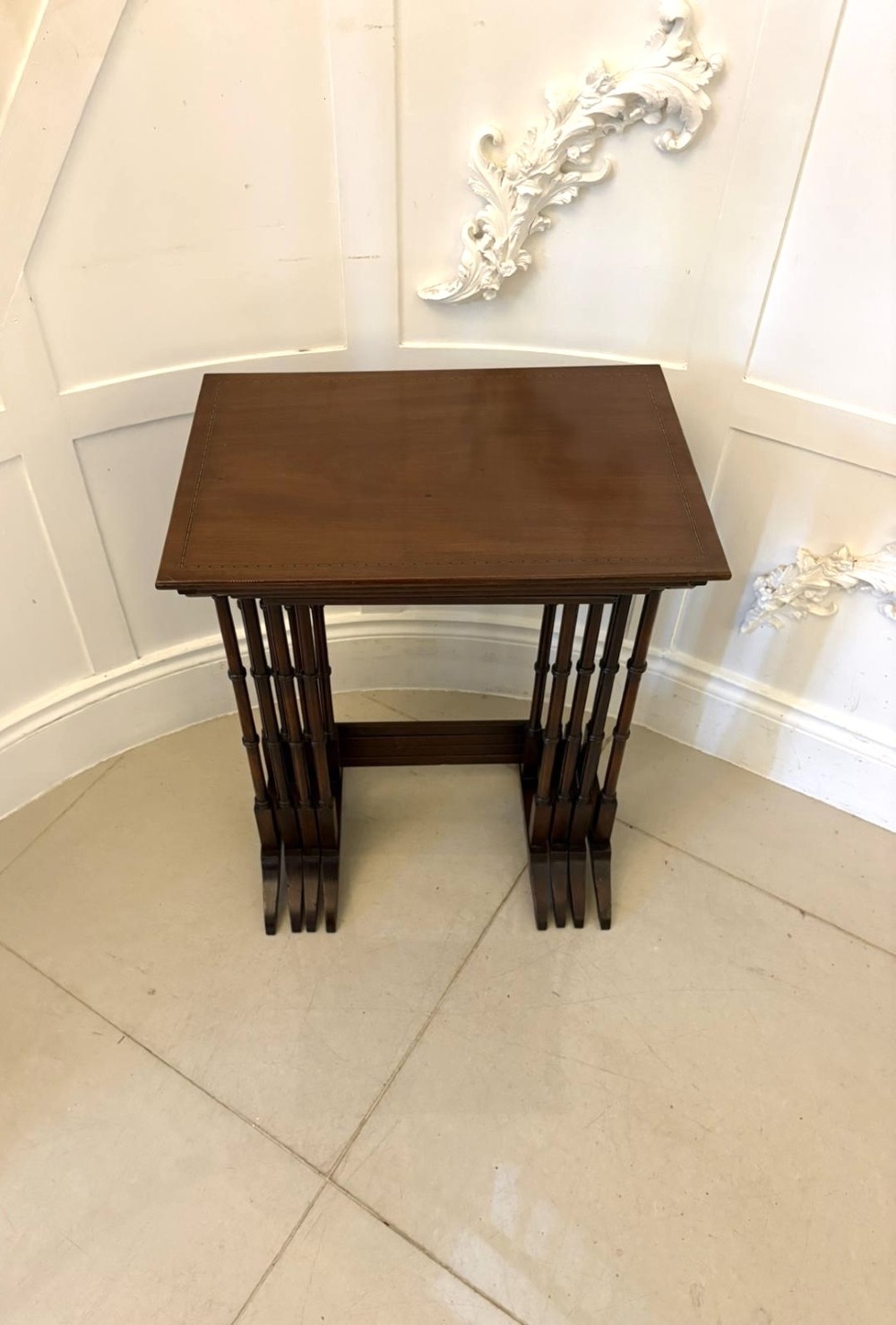 A set of four graduated Edwardian mahogany nesting tables featuring fine satinwood inlay borders and slender turned legs on trestle feet. View VIII