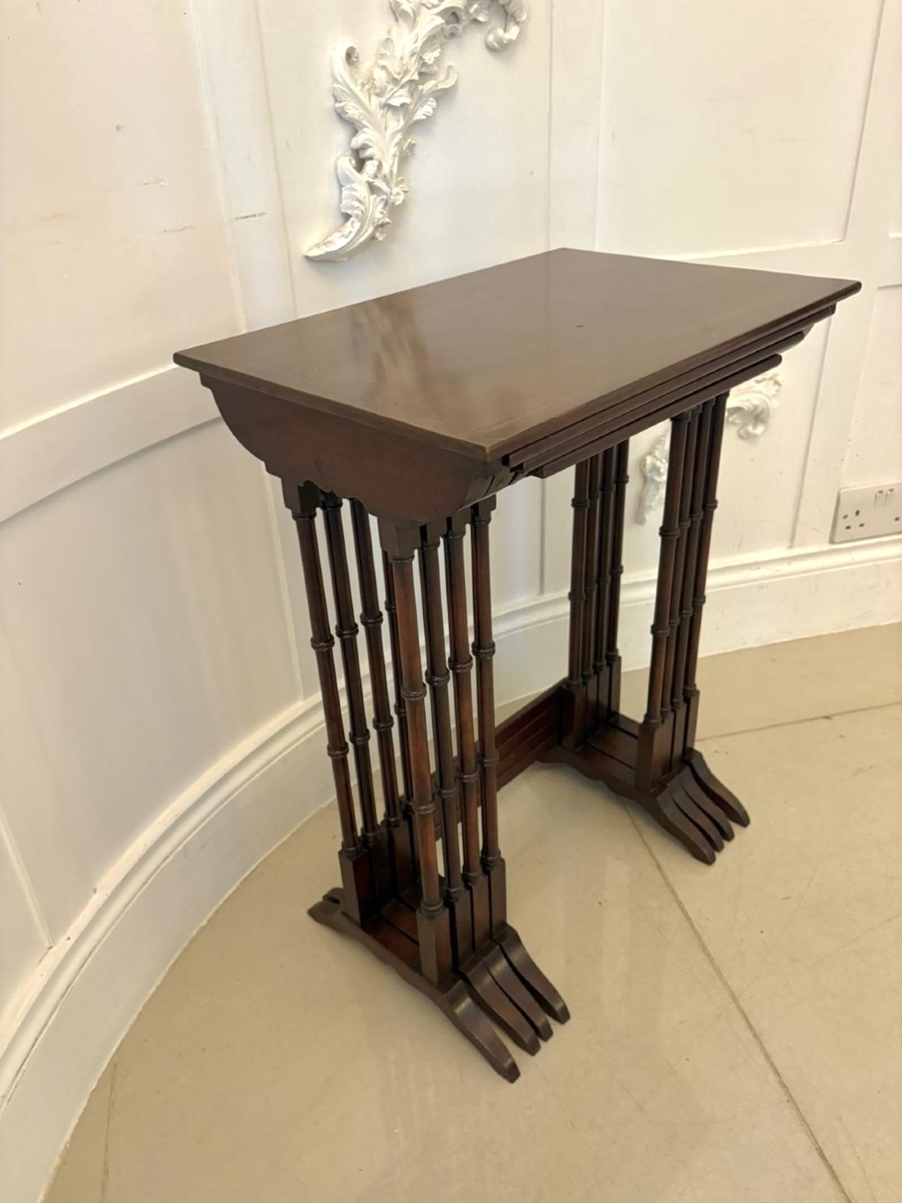 A set of four graduated Edwardian mahogany nesting tables featuring fine satinwood inlay borders and slender turned legs on trestle feet. View IX
