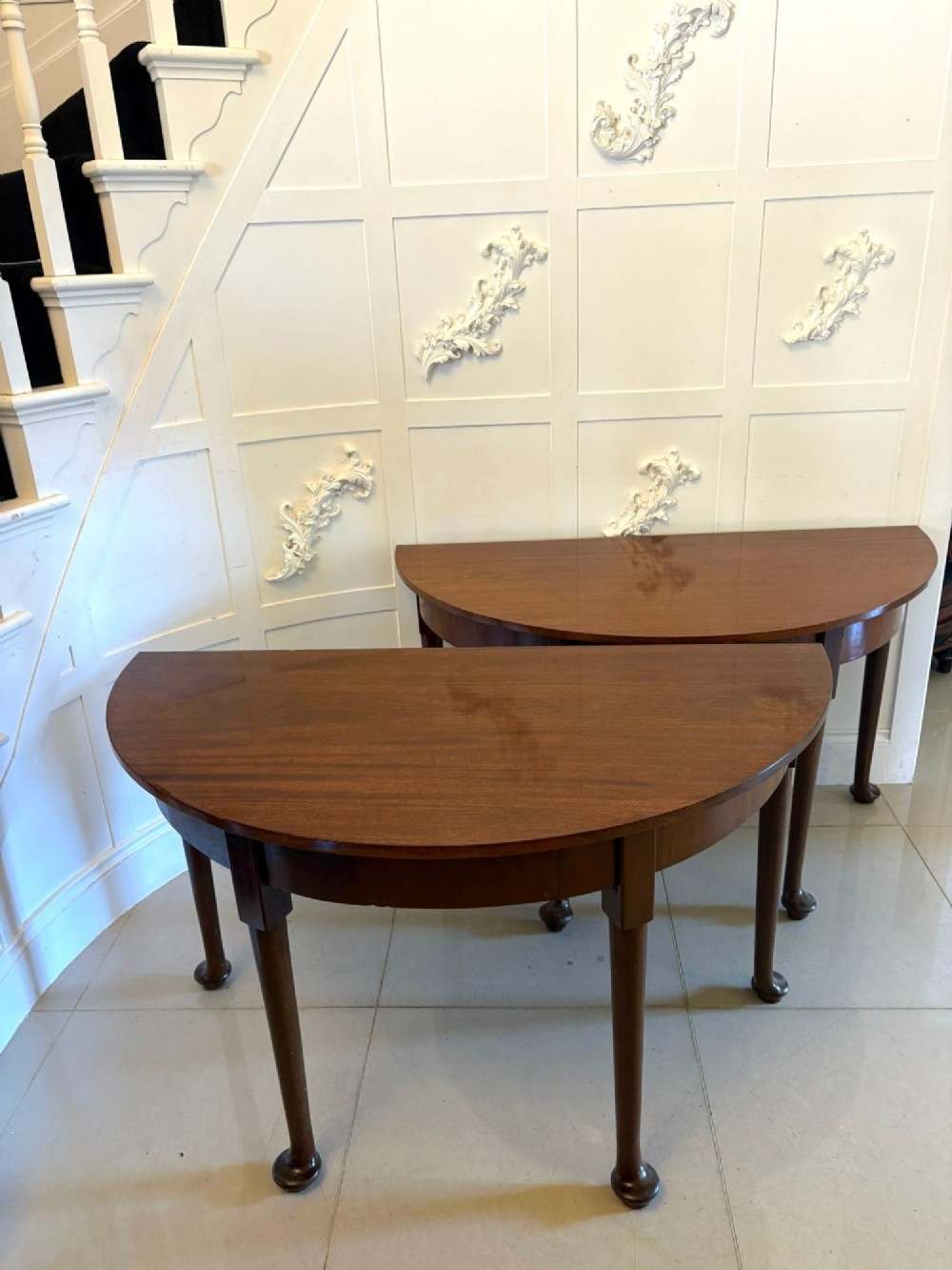 A large extended Georgian mahogany dining table featuring curved D-shaped ends, polished figure top, and slender legs with pad feet. View III