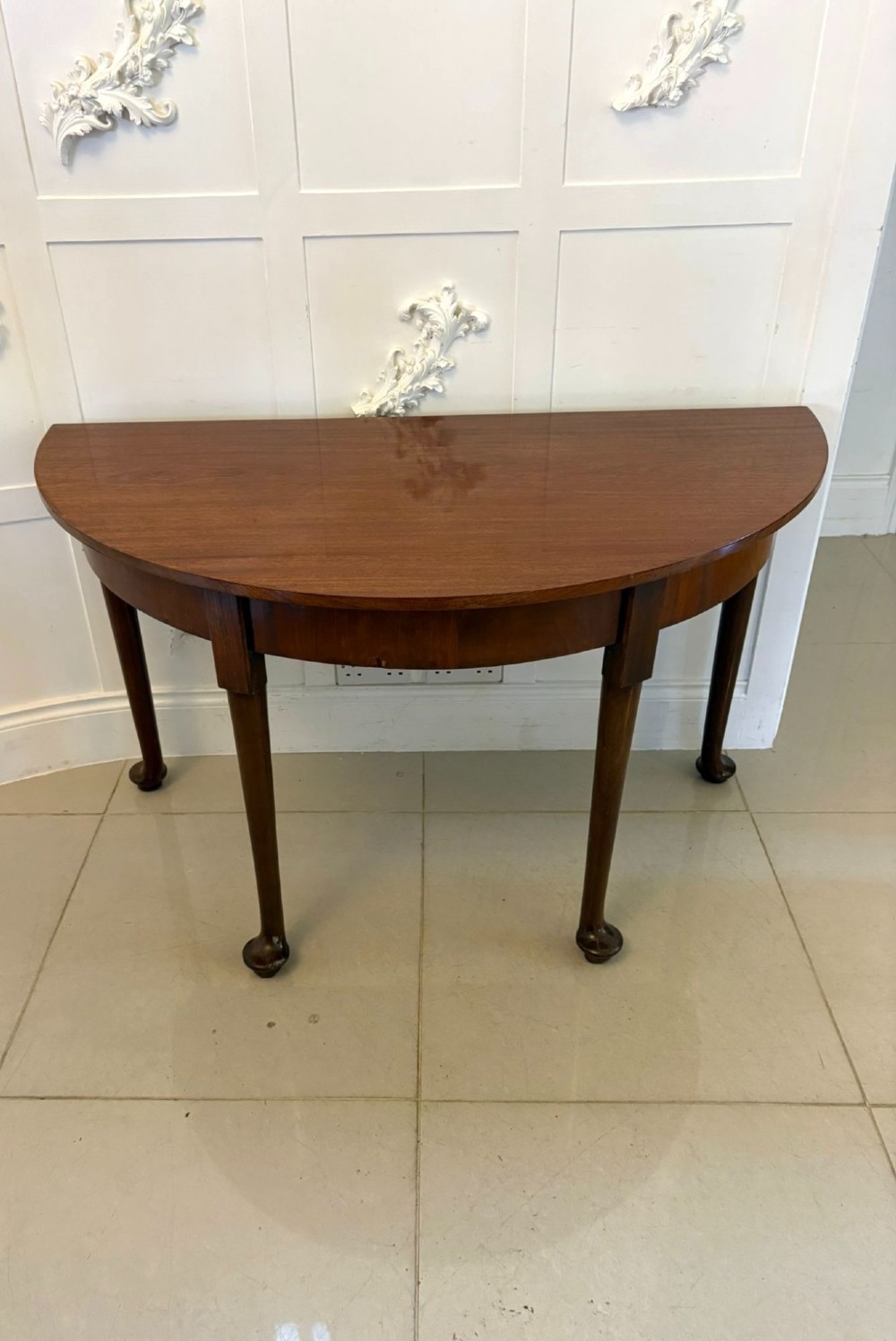 A large extended Georgian mahogany dining table featuring curved D-shaped ends, polished figure top, and slender legs with pad feet. View V