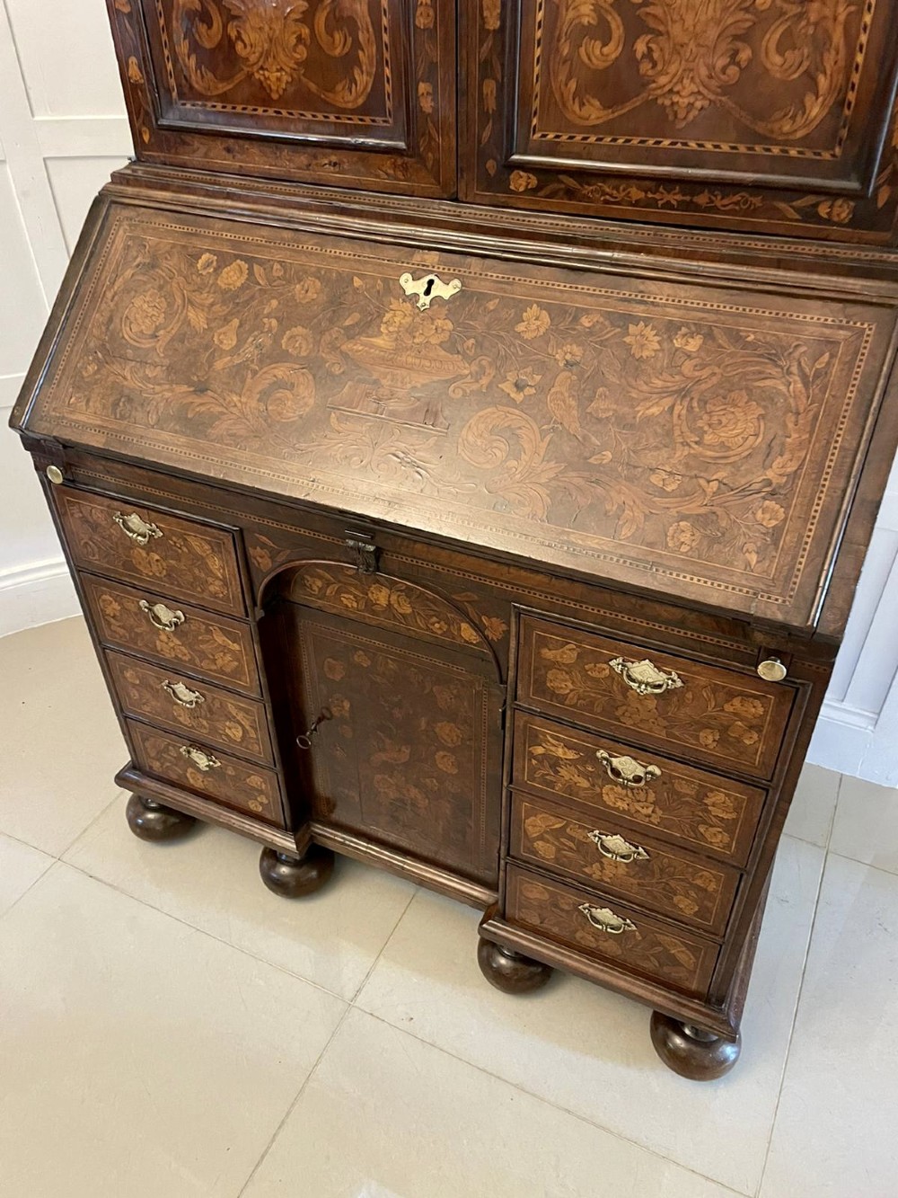 An antique William and Mary double-dome bureau bookcase crafted from burr walnut with intricate floral marquetry inlay and ball feet. View XI