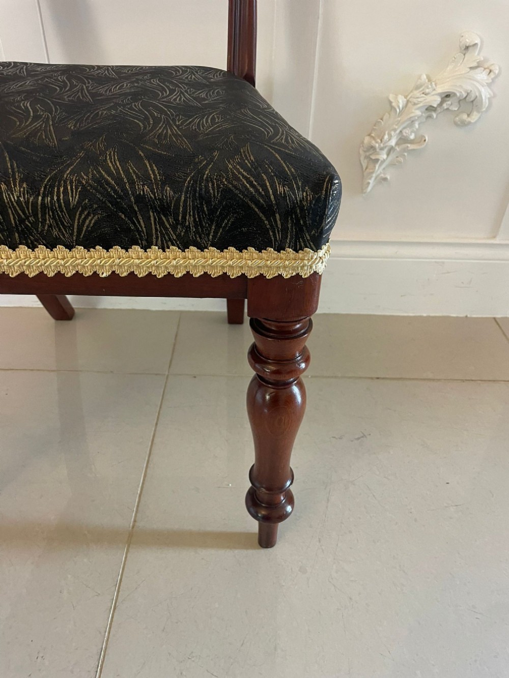 A set of ten Victorian mahogany dining chairs with curved crest rails, turned front legs, and dark pattern upholstered seats. View VII