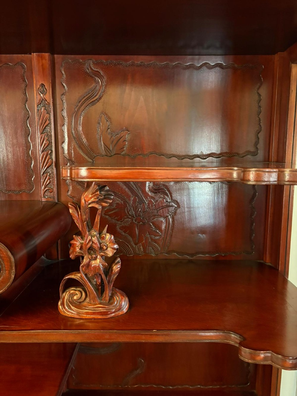 A carved reddish-brown hardwood display cabinet featuring a pagoda cresting, glass door, asymmetrical interior shelves, lower drawers, and cabriole legs. View VIII